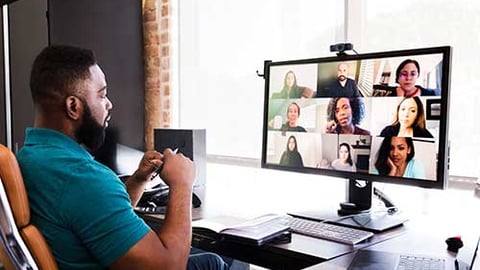 a man sitting at a desk with a laptop computer