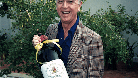 a man wearing a suit and tie smiling at the camera