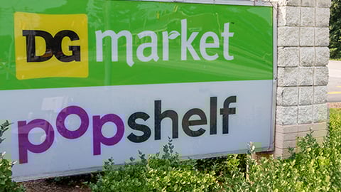 a sign in front of bushes