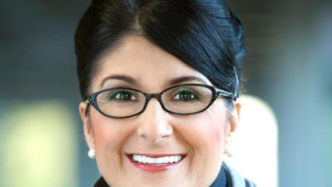 a person wearing glasses and smiling at the camera