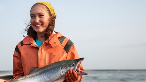 a person holding a fish in the water