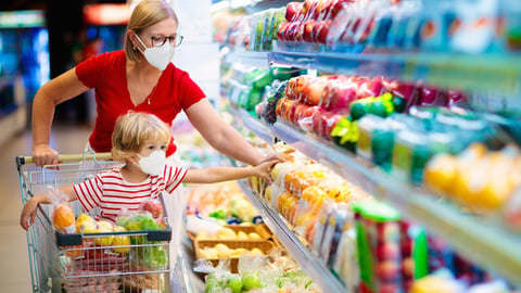 a person standing in front of a store filled with lots of food