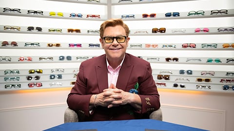 Elton John sitting on a table