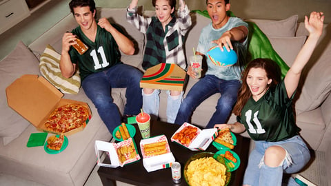 people eating pizza and watching football