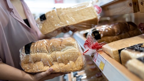 woman holding bagged bread at store