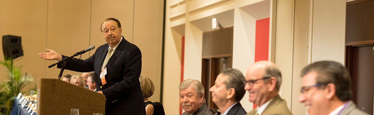 a group of people standing next to a person in a suit and tie