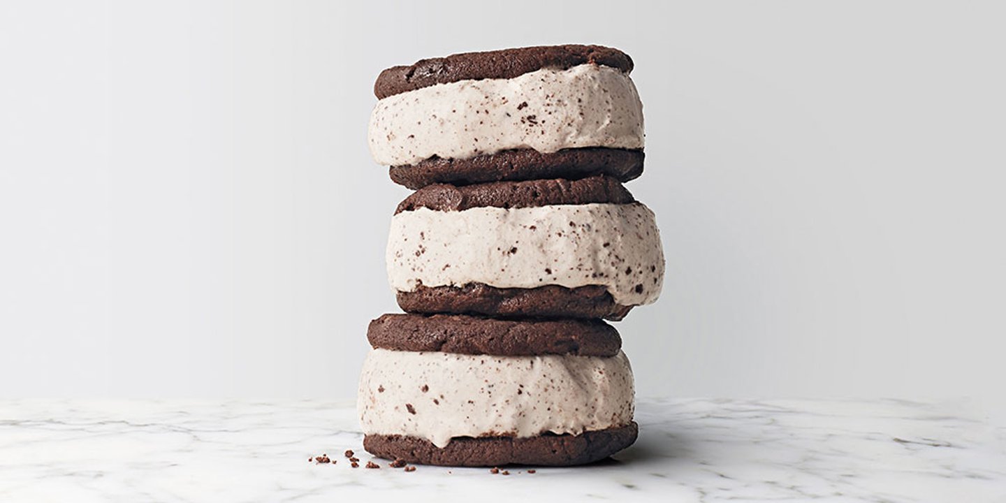 three cookie ice cream sandwiches with cookies and cream filling stacked on top of each other