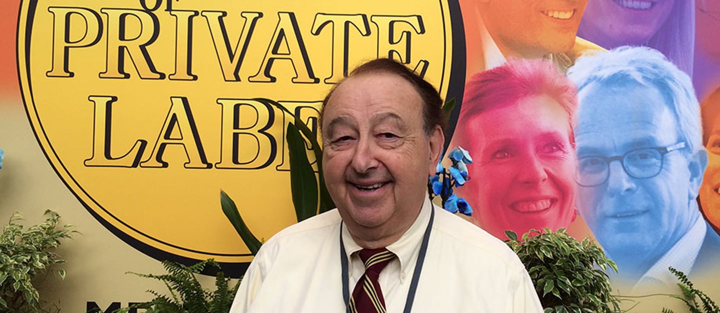 a man wearing a suit and tie smiling at the camera