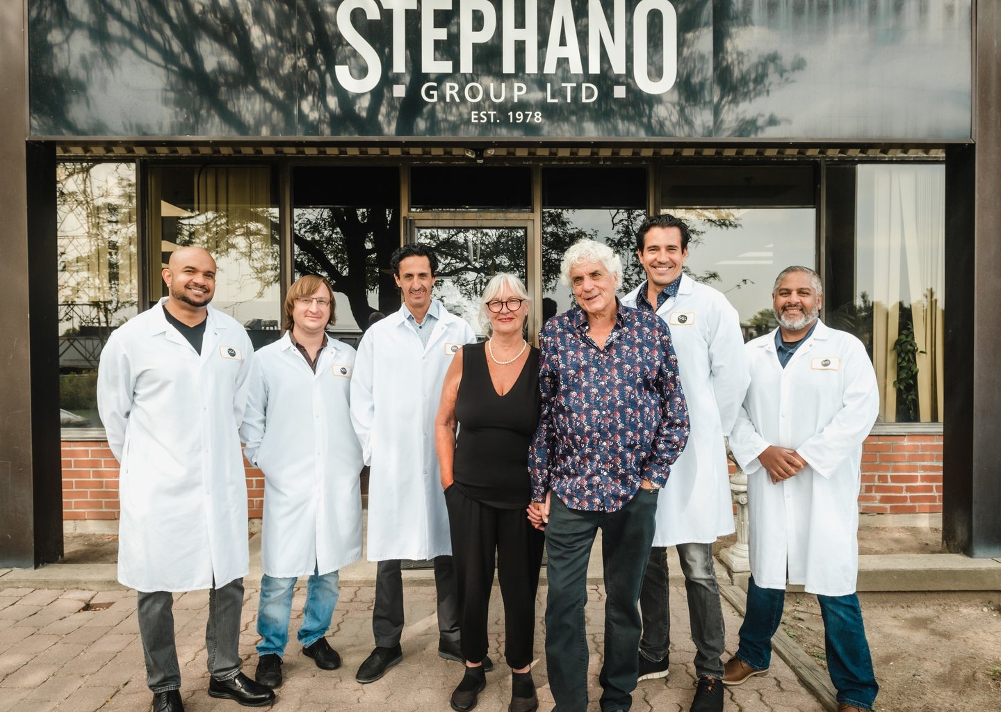 a group of people posing for a photo in front of a building