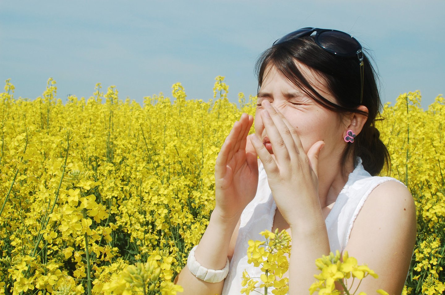 Pollen allergy, girl sneezing in a field of flowers; Shutterstock ID 93088627