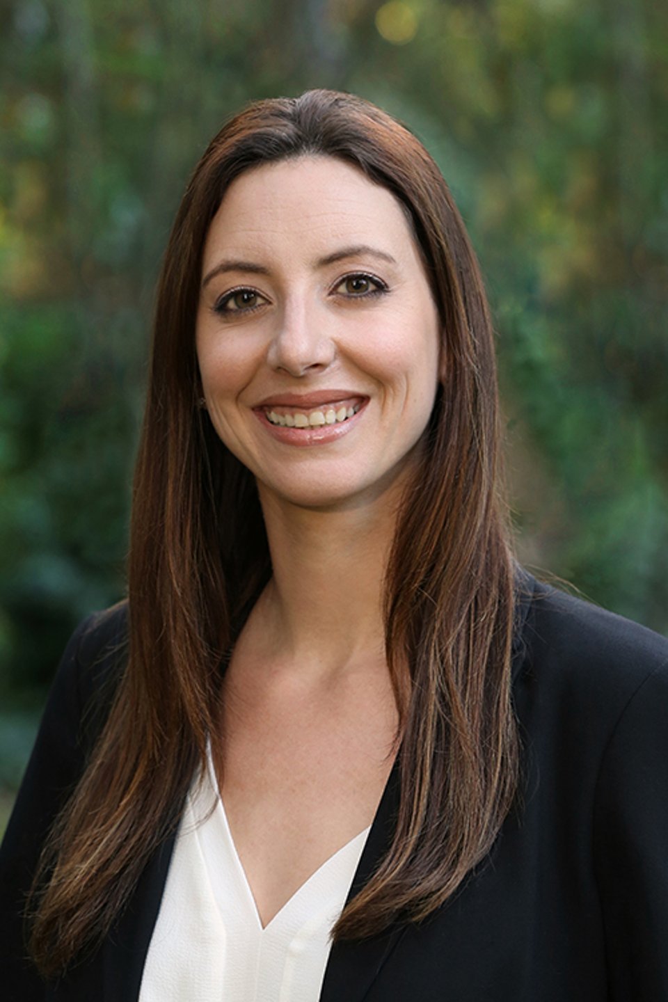 a woman wearing glasses and smiling at the camera