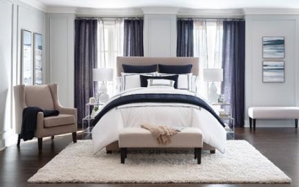 a bed with white and blue sheets