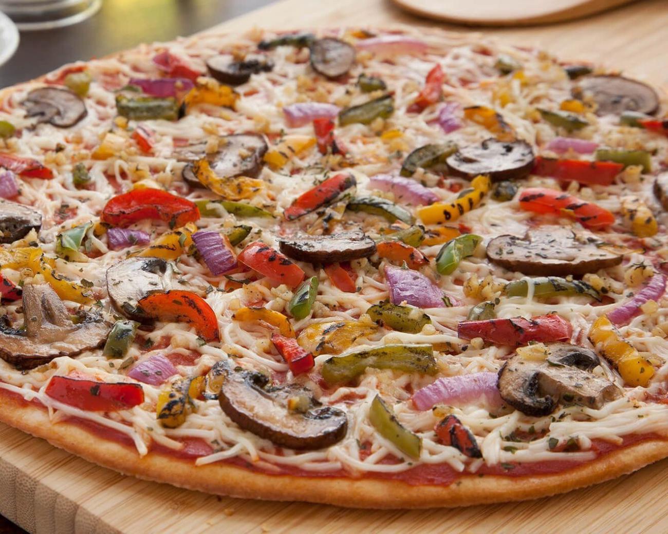 a pizza sitting on top of a wooden table