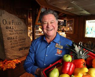 a man standing in front of a fruit stand