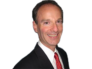 a man wearing a suit and tie smiling at the camera