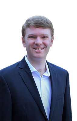 a man wearing a suit and tie smiling at the camera