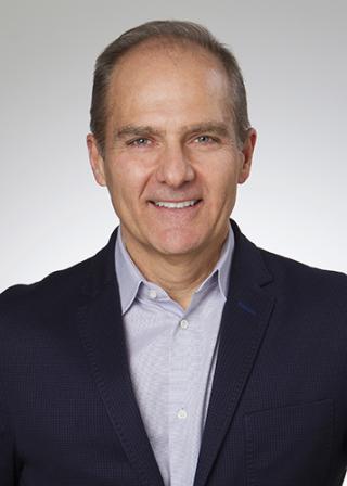 a man wearing a suit and tie looking at the camera