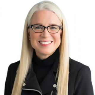 a person wearing glasses and smiling at the camera