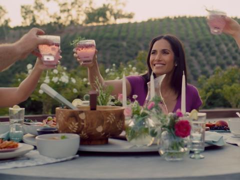 Padma Lakshmi sitting at a table with a cake